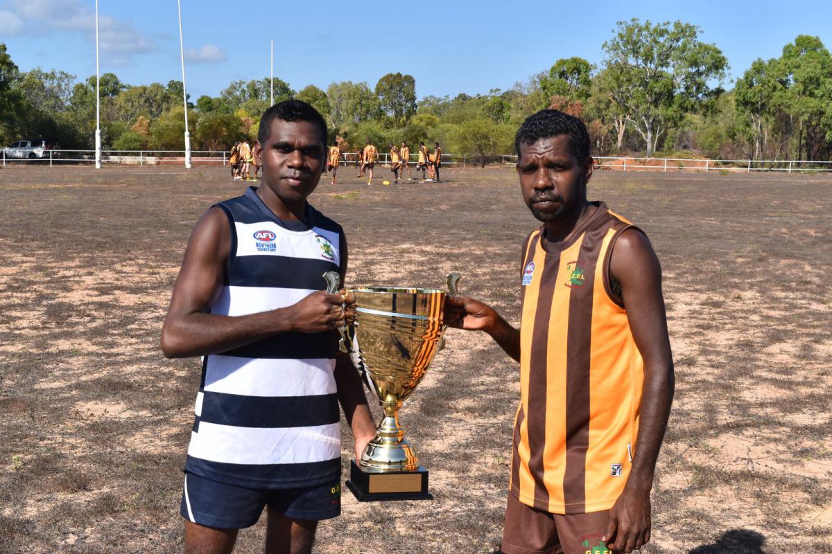 Footy players holding trophy